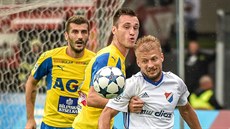 Tomáš Mičola z Baníku (v bílém) v souboji o míč s teplickými fotbalisty. Tomáš Mičola z Baníku (v bílém) v souboji o míč s teplickými fotbalisty.