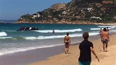 Na pláži mezi turisty přistál člun plný uprchlíků Na pláži mezi turisty přistál člun plný uprchlíků