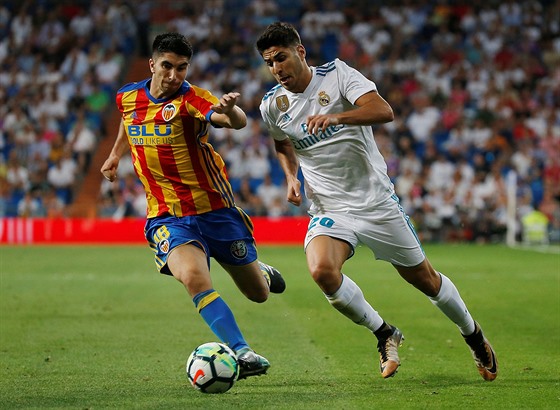 Marco Asensio z Realu Madrid utíká Carlosi Solerovi z Valencie.