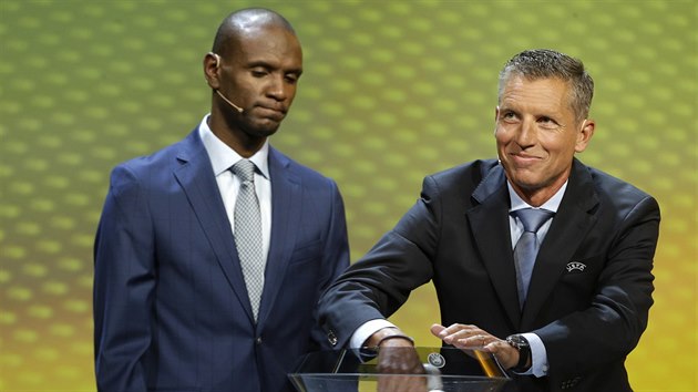 Bval vborn fotbalista Eric Abidal sleduje, jak tm vythne funkcion UEFA Michael Heselschwerdt.