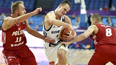 Slovinský basketbalista Klemen Prepeli (v bílém) proniká mezi polskými soupei...