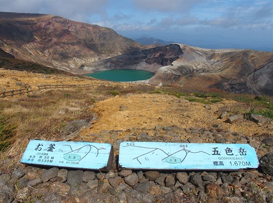 Jezero Okama z vrcholu Katta. Cedule informuje o hloubce, prmru a obvodu...