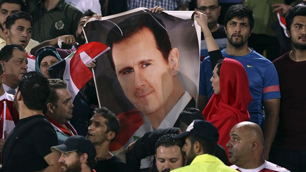 Syrt fotbalov fanouci na tribunch s plaktem prezidenta Bara al-Asada.