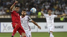 Syrský fotbalista Omar Alsoma (vlevo) v souboji s Mortezou Pouraliganjiho...