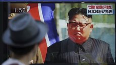 Mu prochází kolem televizní obrazovky, na ní je severokorejský vdce Kim...
