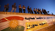 Kurdové z iráckého Duhoku se seli u plakátu, který upozoruje na nadcházející...