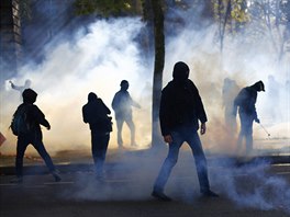 PROTI ZMN. Demonstranti stojí v oblaku slzného plynu bhem protestu proti...