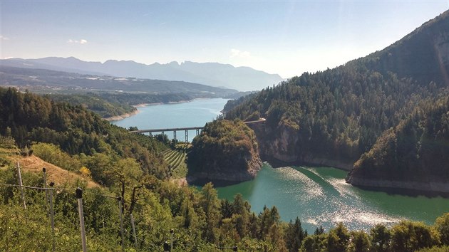 Na trase z Cloz do trentinského údolí údolí Val di Non. Pohled z kopců přes jablečné sady na přehradní jezero Santa Giustina