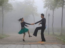 TANEC V MLZE. Mladý pár taní v parku v ínském Chuaj-anu na východním pobeí.