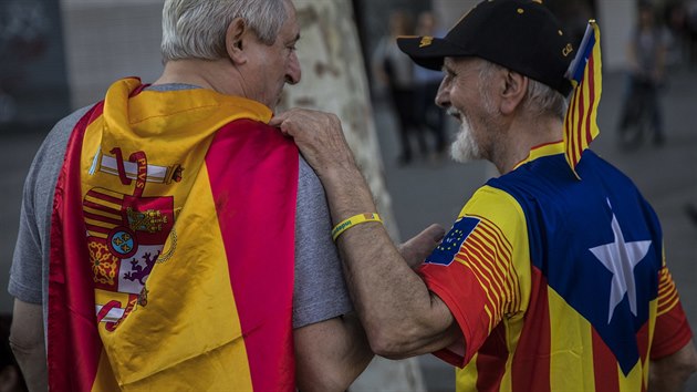 Dva mui, jeden se panlskou vlajku a druh s vlajkou katalnskch separatist, se bav bhem svtench oslav (12. jna 2017)