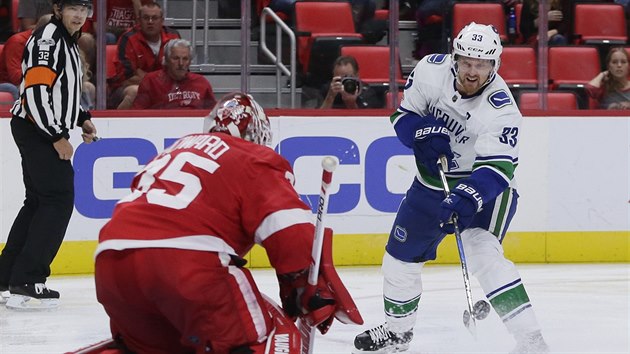 Henrik Sedin z Vancouveru v anci ped detroitskm brankem Jimmym Howardem.