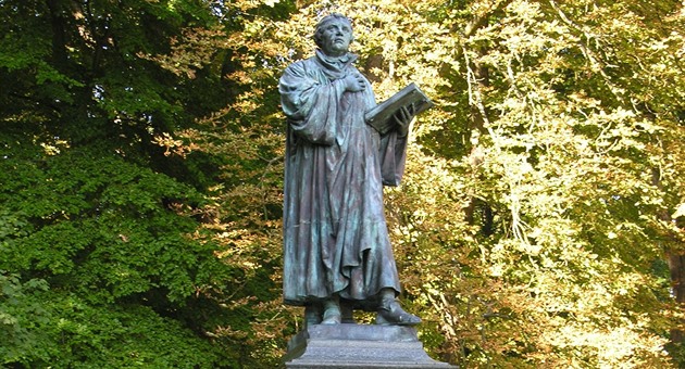 Socha zakladatele reformního hnutí Martina Luthera stojí v Ai vedle památníku...