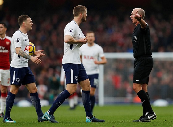 Rozhodí Mike Dean ukazuje fotbalistm Tottenhamu, e své rozhodnutí v utkání...