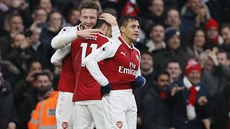 Fotbalisté Arsenalu slaví branku do sít Tottenhamu.