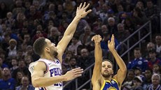 Stephen Curry (v modrém) z Golden State střílí přes Bena Simmonse z... Stephen Curry (v modrém) z Golden State střílí přes Bena Simmonse z...