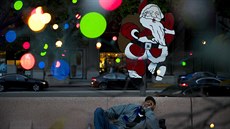 Bezdomovec Alonzo Harrison (47) odpoívá na lavice pod ozdobou Santa Clause v...