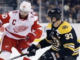 Zdeno Chra (vpravo) z Bostonu a Henrik Zetterberg z Detroitu v souboji o puk.