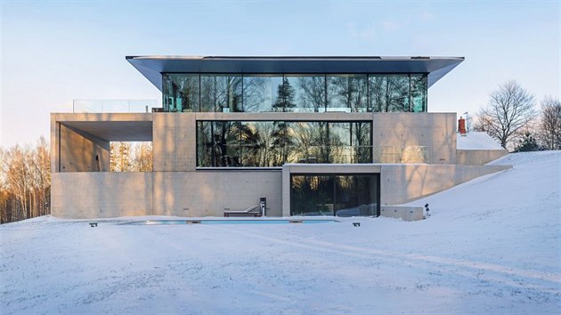 Architekti studia OUTOFBOX tomu kaj asketick design. Impozantn dm ze skla a betonu organicky zapad do terasovitho ternu.