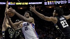 Joel Embiid (v bílém) z Philadelphie mezi Matthewem Dellavedovou (vlevo) a...