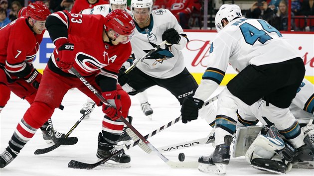 Jeff Skinner z Caroliny (s slem 53) se sna pekonat semknutou obranu San Jose.