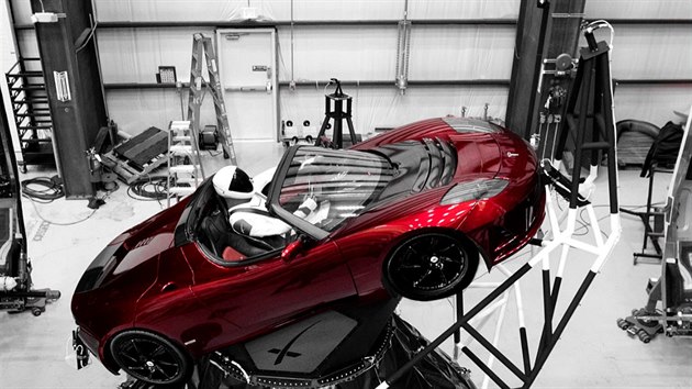 Tesla Roadster a skafandr SpaceX bhem uzavrn nkladu do aerodynamickho krytu. Na snmku jsou tak vidt dv kamery ped vozem a z jeho lev strany. A pokud si obrzek hodn piblte, mon uvidte i mal model stejnho vozu i s figurnou poloen na pedn desce.