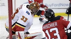 David Rittich z Calgary vyráží puk, atakuje ho Nico Hischier z New Jersey. David Rittich z Calgary vyráží puk, atakuje ho Nico Hischier z New Jersey.
