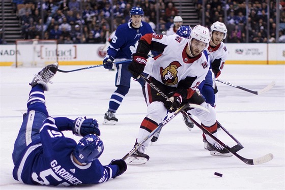 Jake Gardiner z Toronta (vlevo) padá na led po ataku Dericka Brassarda z Ottawy.