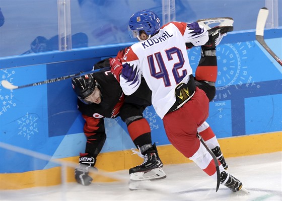 Petr Koukal atakuje u mantinelu jednoho z kanadských hokejist. (17. února 2018)