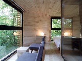 Uvnit stylového stromového domu je lonice s manelskou postelí a obývací...