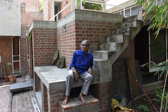 Architekt Balkrina Doi sedí na schodech v bytovém komplexu v Ahmadábádu. 