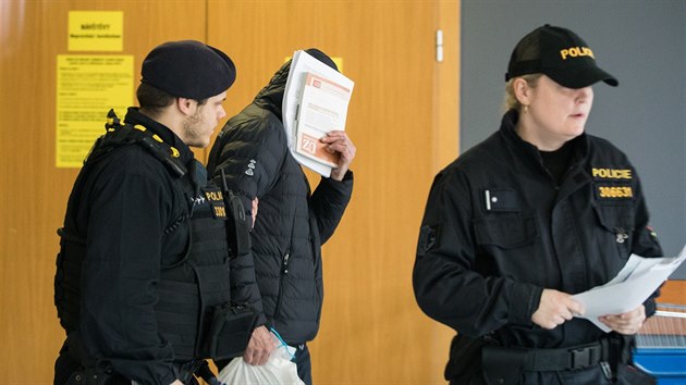 Policist odvdj obvinnho soudce Ivana Elischera (v kapuci) od praskho obvodnho soudu, kter rozhodoval o jeho vazb. (15. bezna 2018)