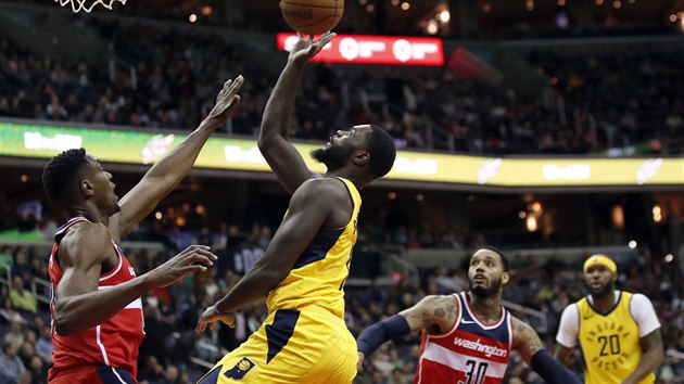 Lance Stephenson (ve lutm) z Indiany zakonuje na washingtonsk ko pes Bradleyho Beala, sleduje ho Mike Scott.