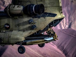 VOJENSKÉ CVIENÍ. Letový technik sedí na nakládací ramp vrtulníku bojových...
