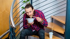 Muž jí jídlo z fastfoodu Muž jí jídlo z fastfoodu