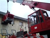 Hasiči jeřábem zvedli k oknu přípojný vozík za auto. Pacienta přeložili na... Hasiči jeřábem zvedli k oknu přípojný vozík za auto. Pacienta přeložili na...