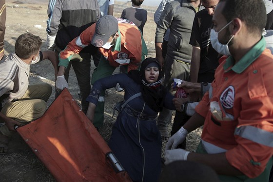 Palestintí demonstranti se snaí naloit zrannou enu na nosítka (15. kvtna...