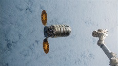 Kosmický náklaák Cygnus u stanice ISS, vpravo je robotické rameno Canadarm2.