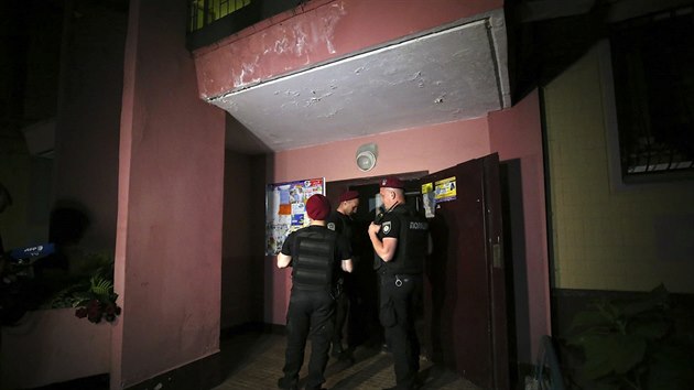 Policie ped vchodem domu, kde byl postelen rusk novin Arkadij Babenko. Zemel v sanitce cestou do nemocnice. (29. kvten 2018)