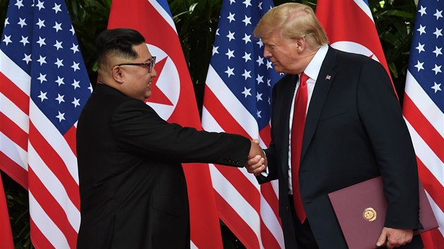 Americk prezident Donald Trump a severokorejsk ldr Kim ong-un si tesou rukama po podpisu zvrenho dokumentu po setkn v Singapuru. (12. ervna 2018)