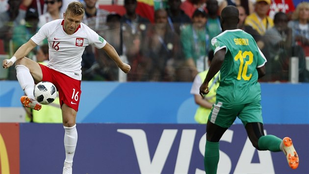 Polsk zlonk Jakub Blaszczykowski zpracovv balon v utkn se Senegalem. Youssouf Sabaly se ho chyst napadat.