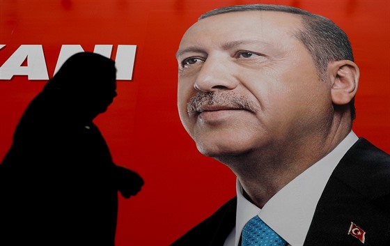 Turkyn prochází pod volebním plakátem tureckého prezidenta Tayyipa Erdogana....