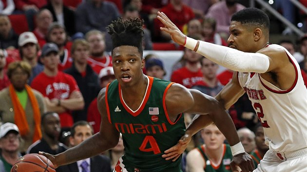 Lonnie Walker IV. (4) z Miami najd ke koi  North Carolina State kolem Allerika Freemana.