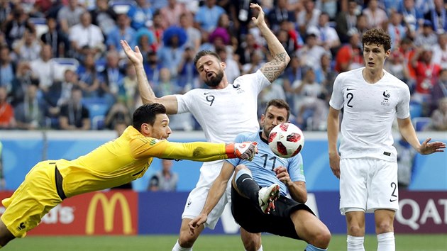 Francouzsk brank Hugo Lloris boxuje m ped tonkem Uruguaye Christhianem Stuanim.