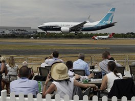 Spectators watch a Boeing 737 land after a flying display at the Farnborough...