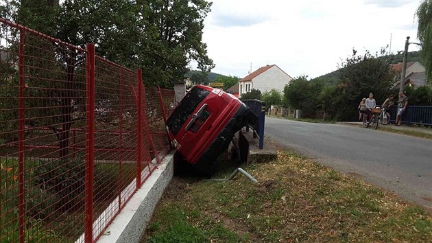 Auto se v Bezin na Tinovsku pevrtilo na bok a skonilo mezi plotem a mostem.