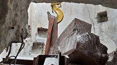 Několikatunový kus kvalitní ocelolitiny je úvazkem připevněn k háku. Několikatunový kus kvalitní ocelolitiny je úvazkem připevněn k háku.