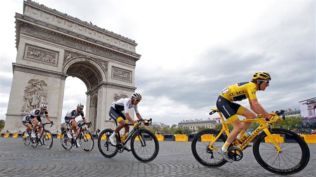 Britsk jezdec Geraint Thomas (ve lutm) projd jako vtz Tour de France v Pai Vtzn oblouk.