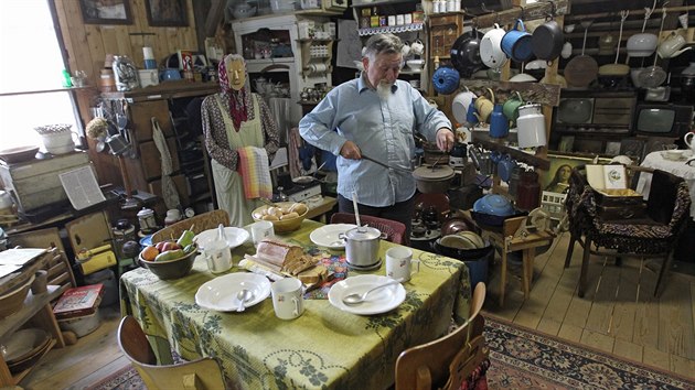 V jedné části stodoly vytvořili autoři vesnickou domácnost. Uprostřed stojí jídelní stůl s dobovými talíři.