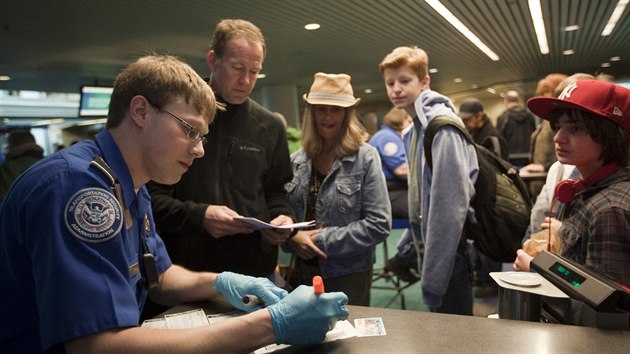 Strnk americkho adu pro bezpenost v doprav (TSA) kontroluje skupinu cestujcch na letiti v Portlandu. (19. bezna 2012)