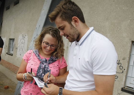 Martin Kaut se podepisuje bhem autogramiády k osmdesátinám árského hokeje.